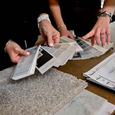 Designer hands reviewing fabric, tile, and finish samples for a room refresh project